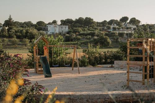 a playground with a slide and a swing set at Essenza Relais Contemporaneo in Cisternino
