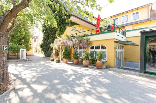 a street in front of a building with potted plants at Stadthotel Kramer in Villach