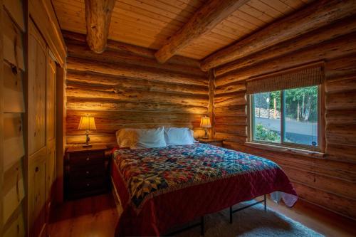 a bedroom with a bed in a log cabin at The Log Cabin in Stevenson