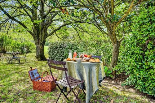 a table with food on it in a garden at Résidence hôtelière et SPA des sources du gros noyer in Malaucène