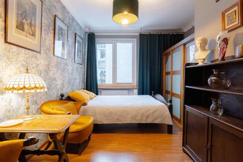 una camera da letto con un letto, un tavolo e delle sedie di Art Apartament Chmielna 10 a Varsavia
