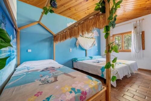 Habitación con 2 camas, paredes azules y techos de madera. en Deltaprego, en Deltebre