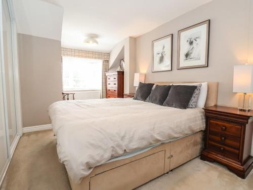 a bedroom with a large bed with a wooden dresser at Chapel House in Brough