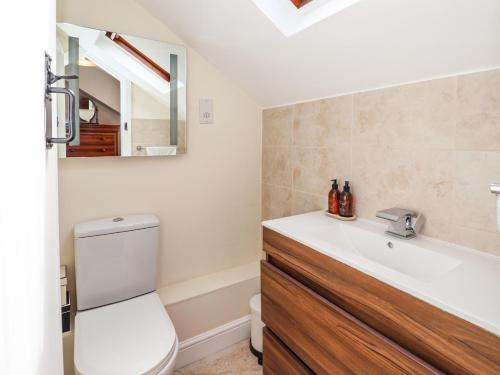 a bathroom with a toilet and a sink and a mirror at Chapel House in Brough