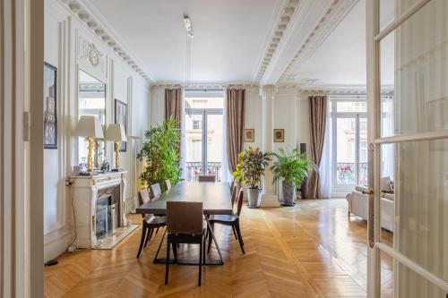 une salle à manger avec une table et des chaises et une cheminée dans l'établissement Prestigious Appartement Trocadero, à Paris