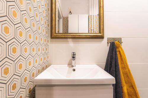un bagno con lavandino e specchio di Art Apartament Chmielna 10 a Varsavia