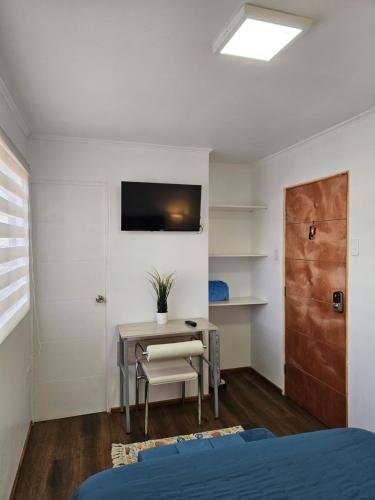 a bedroom with a desk and a table with a chair at Guest House Club Hípico in Santiago