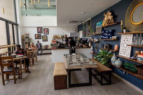 um restaurante com uma mesa e pessoas sentadas às mesas em Skyline 1 Bed, Loft 2 @Embassy Gardens em Cantonments