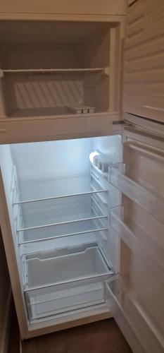 an empty refrigerator with its door open and empty shelves at Casa Torri in Tarquinia