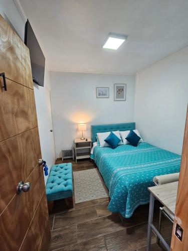 um quarto com uma cama azul e um edredão azul em Guest House Club Hípico em Santiago