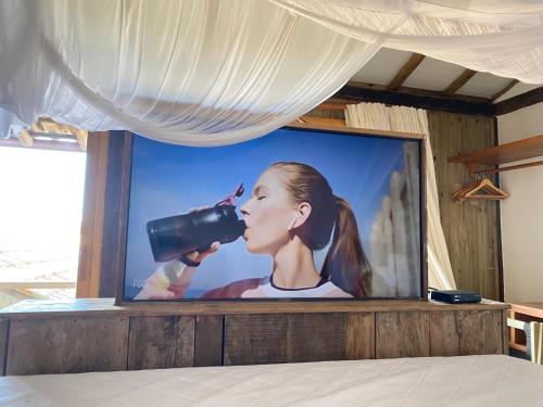 a television with a picture of a woman with a camera at Pausa Trancoso in Trancoso