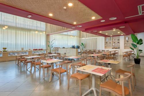 a restaurant with tables and chairs in a room at Hotel Ultonia in Girona