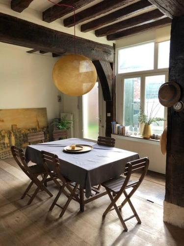 une salle à manger avec une table et des chaises dans une pièce dans l'établissement Grande maison de caractère centre ville de Rouen, à Rouen