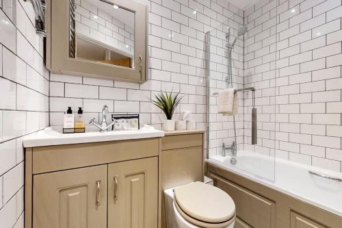倫敦的住宿－Bright & beautiful 1 bedroom flat in London Bridge，浴室配有卫生间、盥洗盆和浴缸。