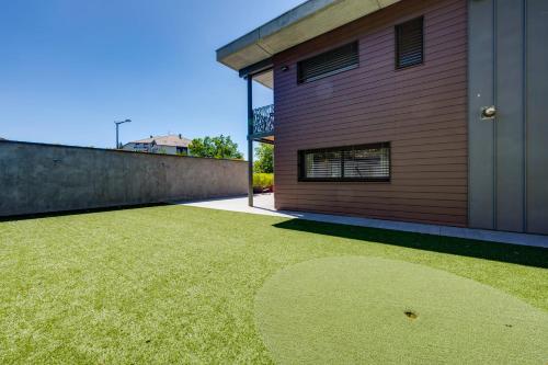 a backyard with a grassy yard next to a building at Le Kube - Appartements de Prestige au centre d'Annecy in Annecy
