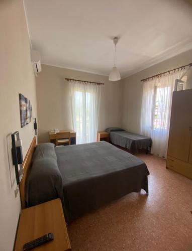 a hotel room with two beds and a table and a bed at Hotel Sole in Marina di Massa