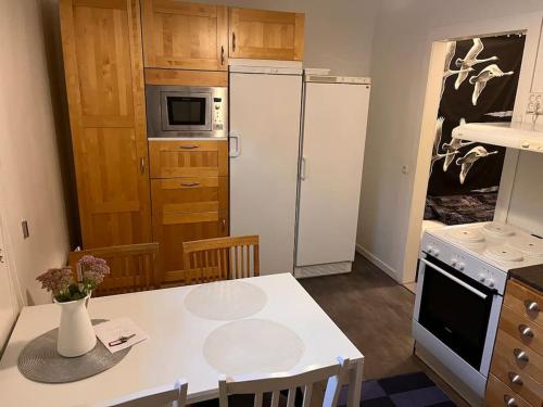 a kitchen with two refrigerators and a table in a room at Lägenhet med sjötomt. Vildmark i tätort. in Umeå