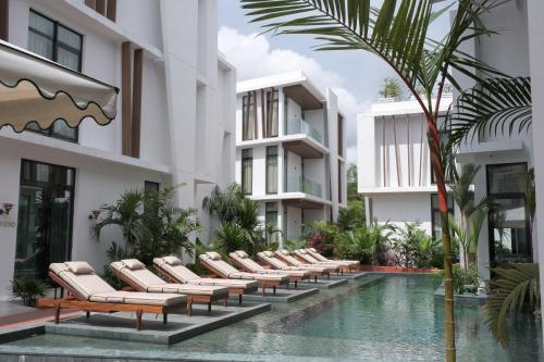 a row of lounge chairs next to a swimming pool at La Maison Palmier Abidjan, a Member of Design Hotels in Abidjan