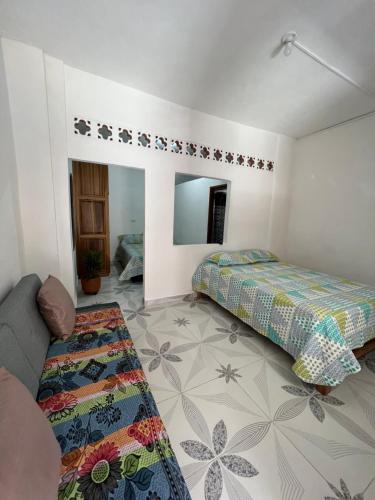 a bedroom with two beds and a couch and a mirror at Apartamento a 5 minutos del parque principal in Jardin
