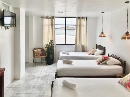 佩德納萊斯的住宿－HOTEL PLAYAS PERDERNALES ECUADOR，一间设有三张床和一台电视的房间