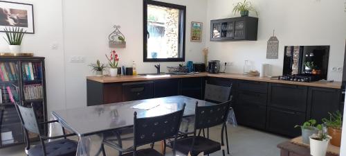 a kitchen with a table and a table and chairs at La villa du pressoir, classé 3 étoiles meublé de tourisme in Le Pallet
