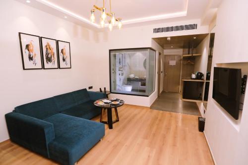 a living room with a blue couch and a tv at Regenta Place Amritsar by Royal Orchid Hotels Limited in Amritsar