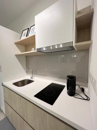 a white kitchen with a sink and a stove at COMFY SKY SUITE Free Wifi & Netflix in Kajang