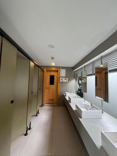 Baño con 4 lavabos y una fila de espejos en COMFY SKY SUITE Free Wifi & Netflix en Kajang