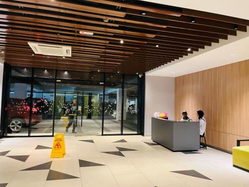a lobby with a woman standing at a counter at COMFY SKY SUITE Free Wifi & Netflix in Kajang