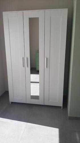 a white cabinet with a mirror in a room at SEVEN HOUSE in Bra