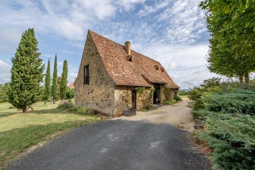 an old stone house on a road at Gîte lOragée Les Farguettes in Cadouin