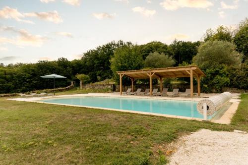 a swimming pool with a gazebo next to a field at Gîte lOragée Les Farguettes in Cadouin