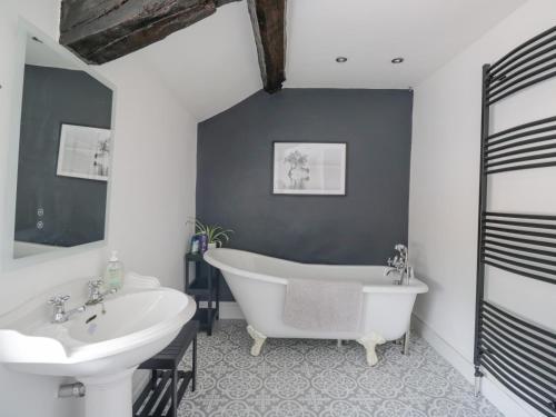 a bathroom with a white tub and a sink at The Hollies in Carlisle