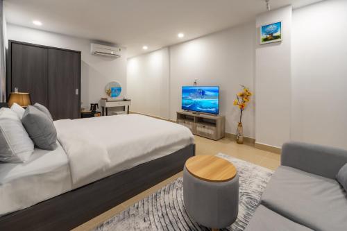 a bedroom with a bed and a tv and a couch at Shogun Hotel in Ho Chi Minh City