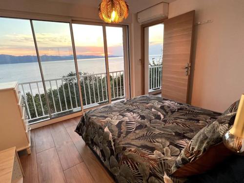 1 dormitorio con cama y vistas al océano en Saint-Florent, Sublime Vue Mer plage 5mn à pied en Patrimonio