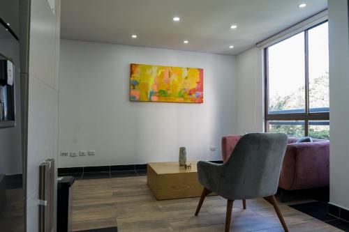 a living room with a chair and a painting on the wall at FASCINANTE ALOJAMIENTO in Bogotá