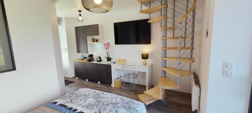 ein Wohnzimmer mit einer Treppe und einem TV in der Unterkunft Duplex à la Beardiére in Évron