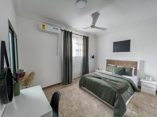 Un dormitorio con una cama y una mesa. en Cozy minimal suite en Accra