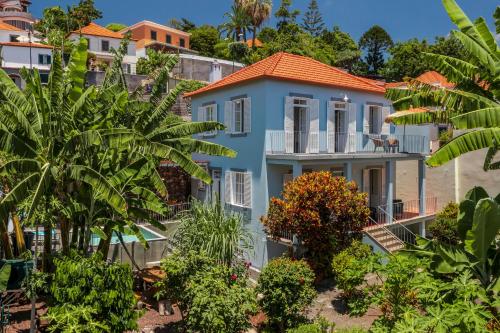 a blue house with an orange roof at Villa Quebra Costas by An Island Apart in Funchal