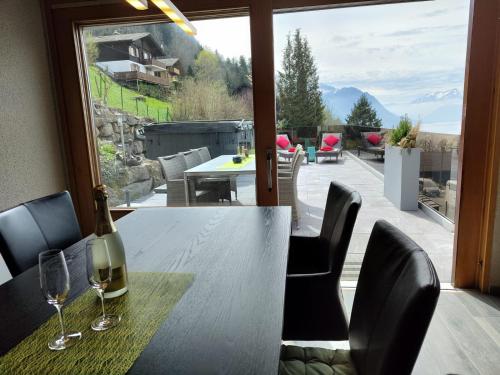 a bottle of wine sitting on a table with a window at Traumhafte Villa Seelisberg in Seelisberg