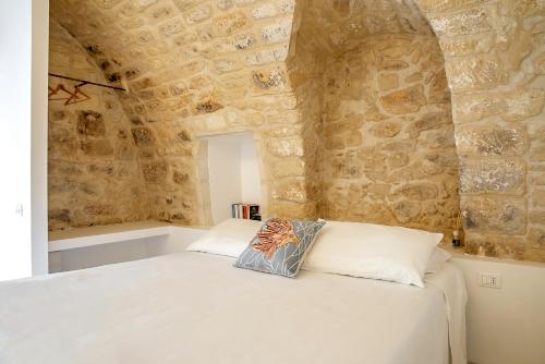 um quarto com uma cama numa parede de pedra em Mazzini 5 em Ragusa