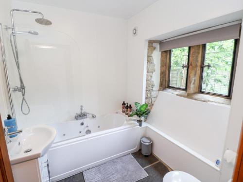 a white bathroom with a tub and a sink at The Gatehouse in Sutton in Ashfield