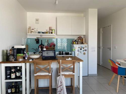 - une cuisine avec une table et un ordinateur portable dans l'établissement T2 au pieds du métro, la soie, à Villeurbanne
