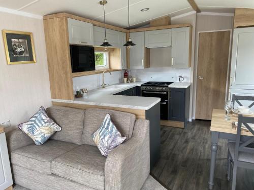 a living room with a couch and a kitchen at Splendid View Caravan in Gisburn