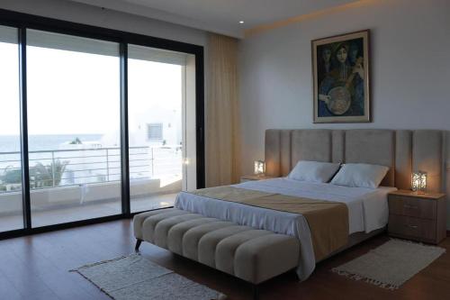 1 dormitorio con 1 cama grande y ventana grande en DIAR SIDI VILLAS DE LUXE, en Kelibia