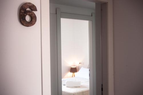 a mirror in a room with a bed and a lamp at Hostal Bon Sol in Sant Ferran de Ses Roques
