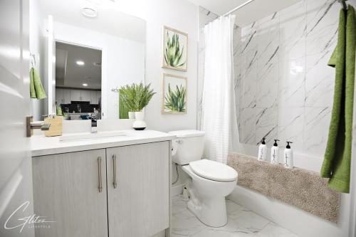 ein weißes Badezimmer mit Toilette und Waschbecken in der Unterkunft Beautiful Suite King Bed,Long Stays,Disney,Airport in Edmonton