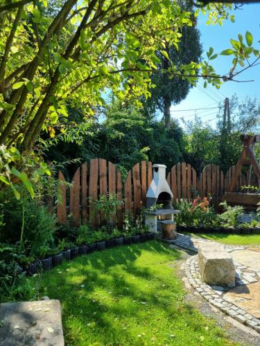 a backyard with a fence and a garden with a fountain at Domek Drwala k. Karpacza in Sosnówka