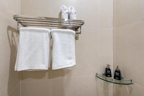a bathroom with white towels hanging on a rack at Shogun Hotel in Ho Chi Minh City