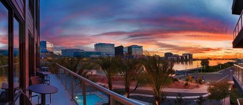 a view of a city at sunset from a balcony at Modern Town Lake Waterfront CozySuites Paradise 07 in Tempe